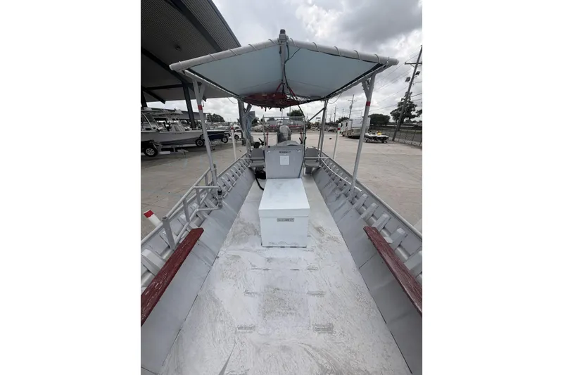 Slide: The Image of 2012 Southfork 27 boat with canopy, docked in a marina under cloudy skies. - 11
