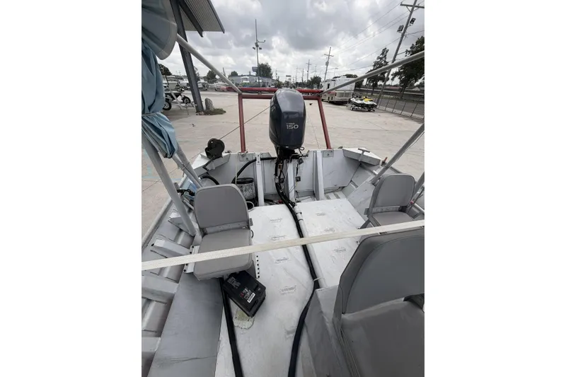 Slide: The Image of 2012 Southfork 27 boat interior with Yamaha 150 outboard motor, parked outdoors. - 13