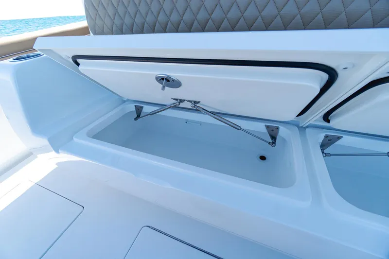 Slide: The Image of 2025 Valhalla Boatworks V-46 storage compartment with open lid and cushioned seating. - 14