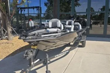 The Image of 2027 Tracker Pro Team 190 TX fishing boat on trailer, parked outdoors. - 0