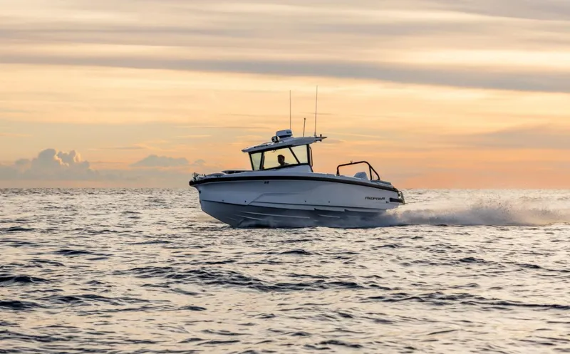 Slide: The Image of 2025 Axopar 29 CCX boat cruising at sunset on open water. - 12