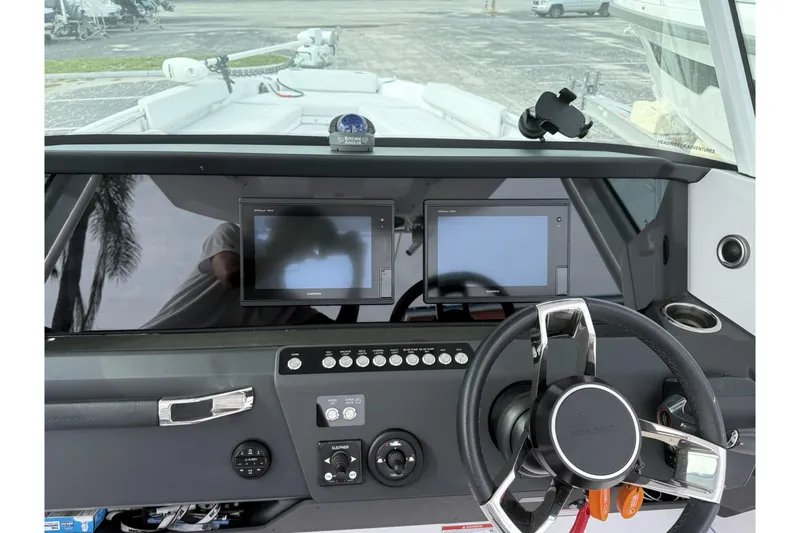 Slide: The Image of 2025 Axopar 29 CCX dashboard with steering wheel and dual display screens. - 6