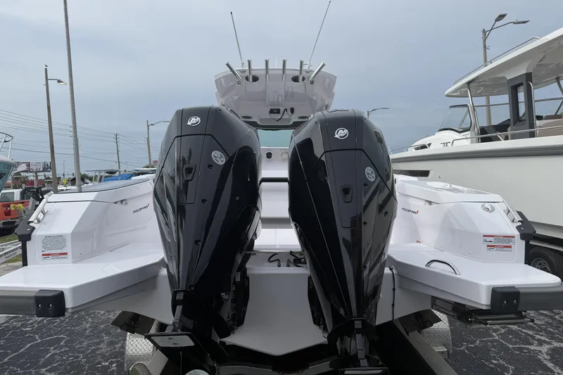 Slide: The Image of 2025 Axopar 29 CCX boat with dual outboard engines, docked at a marina. - 3