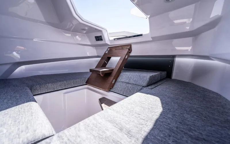 Slide: The Image of Interior cabin of 2025 Axopar 29 CCX boat with gray cushions and wooden accents. - 16