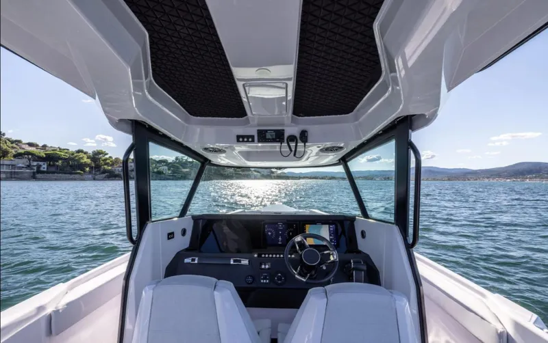 Slide: The Image of Interior view of 2025 Axopar 29 CCX boat cockpit on open water. - 15