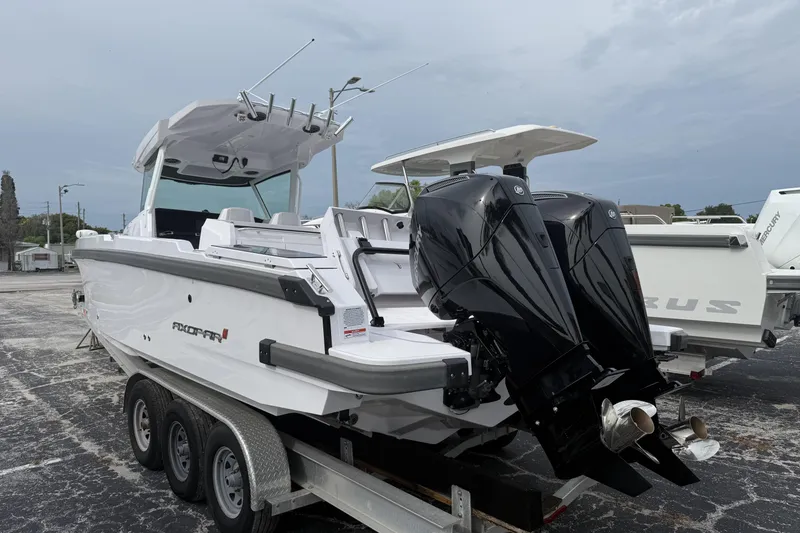 Slide: The Image of 2025 Axopar 29 CCX boat with dual outboard motors on a trailer. - 2