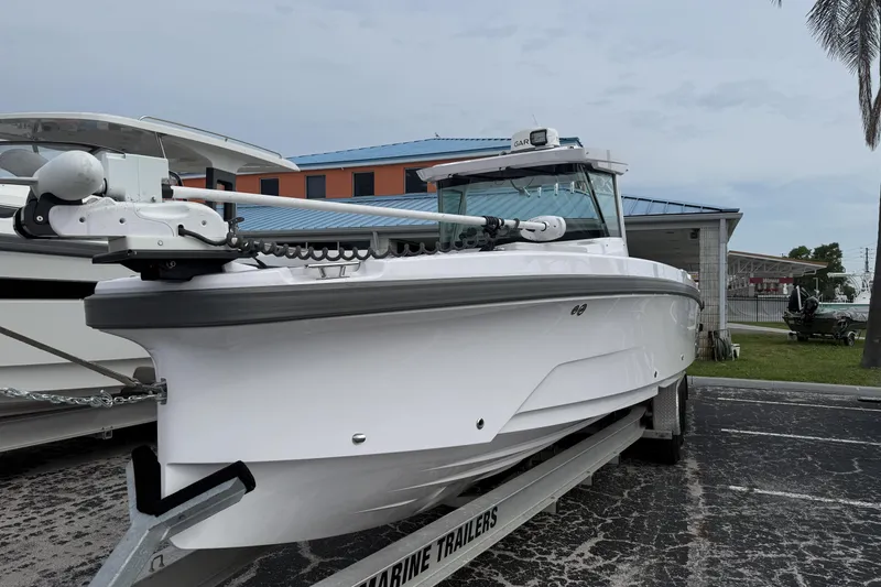 Slide: The Image of 2025 Axopar 29 CCX boat on trailer, sleek design, parked outdoors. - 1