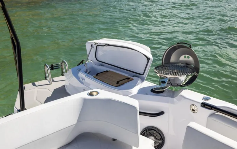 Slide: The Image of 2025 Axopar 29 CCX boat with outdoor grill and storage, on calm water. - 18