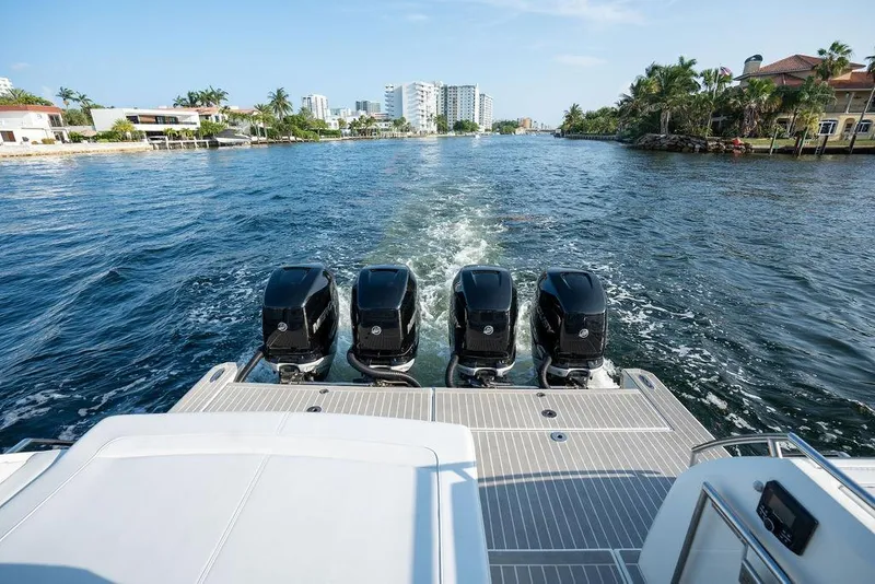 Slide: The Image of The image shows the stern of a boat with four outboard engines on a waterway in a city. - 27