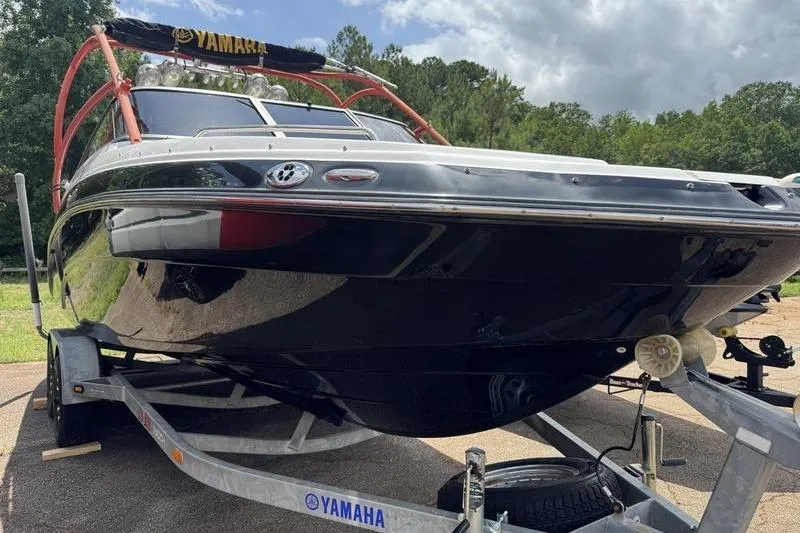 Slide: The Image of 2011 Yamaha Boats AR240 HO on trailer, sleek black design, parked outdoors. - 8