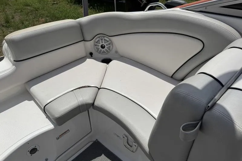 Slide: The Image of 2011 Yamaha Boats AR240 HO interior seating with speaker, featuring white and gray upholstery. - 13