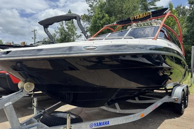 The Image of 2011 Yamaha Boats AR240 HO on trailer, black hull, parked outdoors. - 1
