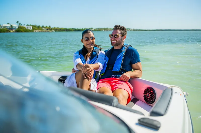 Slide: The Image of A couple sits smiling on a Yamaha 195S boat on the water. - 18
