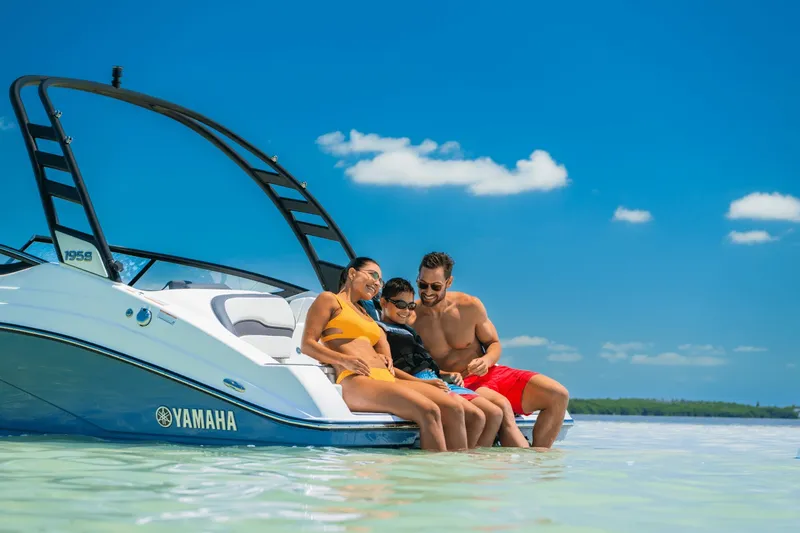 Slide: The Image of A family sits on a Yamaha 195S boat in clear water under a blue sky. - 25