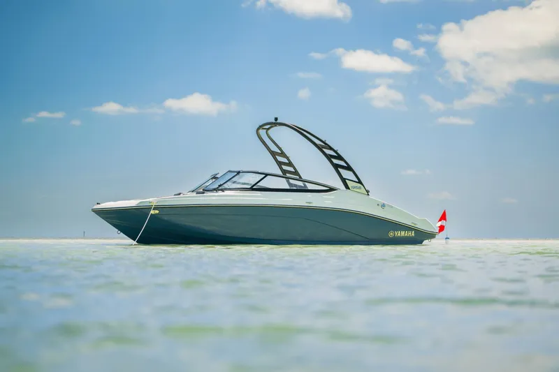 Slide: The Image of A sleek 2024 Yamaha 195S boat floats on calm water under a clear blue sky. - 24