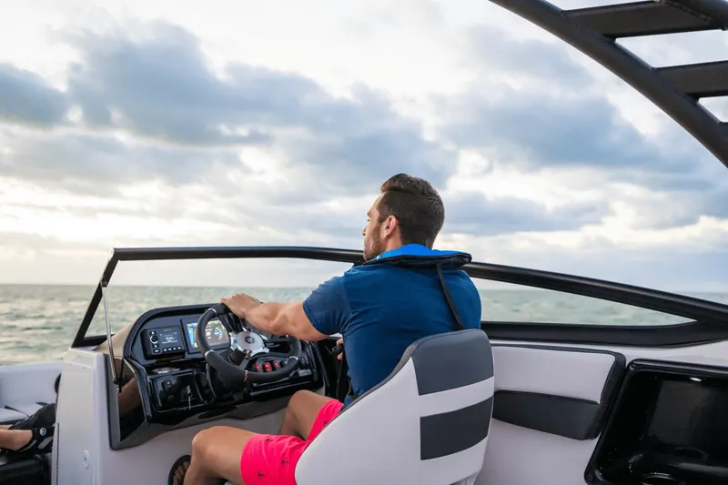 Slide: The Image of A man steers a Yamaha 195S boat on the sea under a cloudy sky. - 12