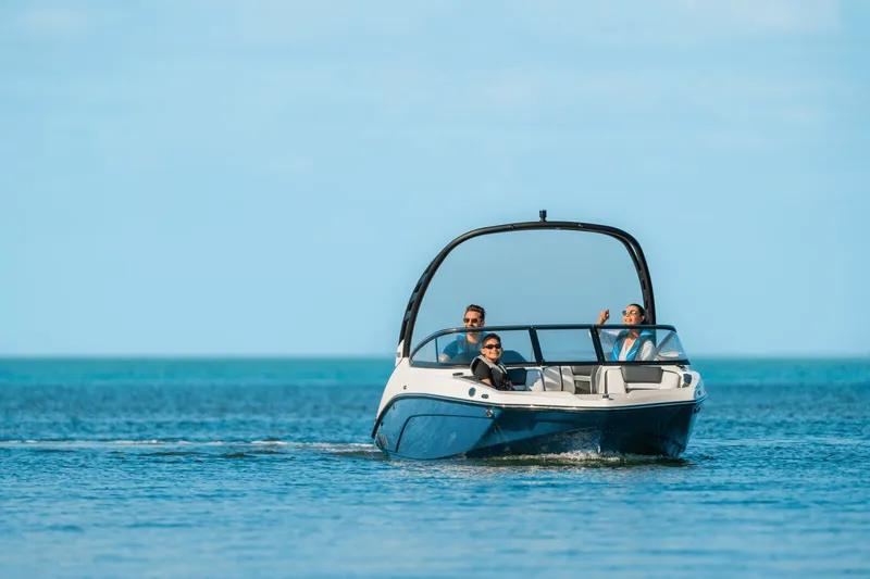 Slide: The Image of A 2024 Yamaha 195S boat cruising on calm water with three people on board. - 4