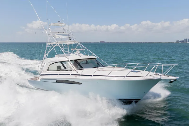 Slide: The Image of 2022 Bertram 50 Sport yacht cruising on open water under clear skies. - 1