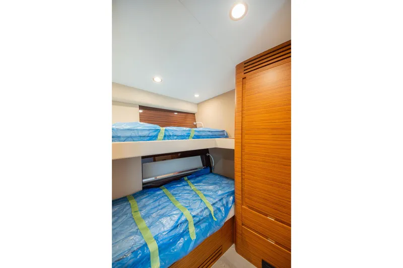 Slide: The Image of Interior of 2022 Bertram 50 Sport yacht featuring cozy bunk beds and wooden cabinetry. - 26