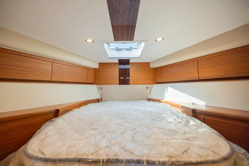Slide: The Image of Luxurious cabin interior of 2022 Bertram 50 Sport yacht with wood paneling and skylight. - 24