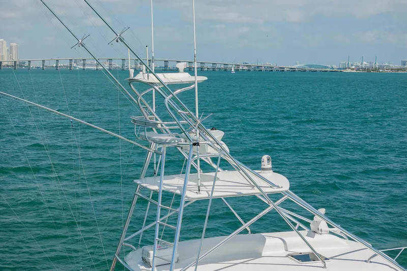 Slide: The Image of 2022 Bertram 50 Sport yacht with tower, cruising on blue ocean near city skyline. - 3