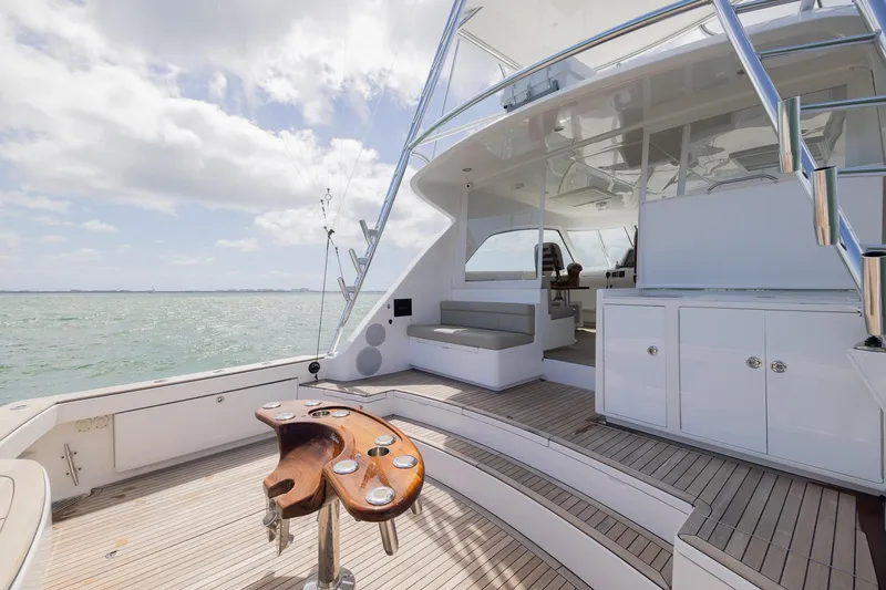 Slide: The Image of 2022 Bertram 50 Sport yacht deck with seating, ocean view, and fishing rod holders. - 9