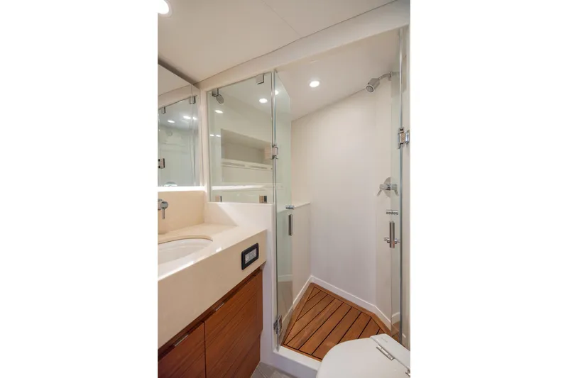 Slide: The Image of Modern bathroom interior on 2022 Bertram 50 Sport yacht, featuring glass shower and wooden accents. - 25