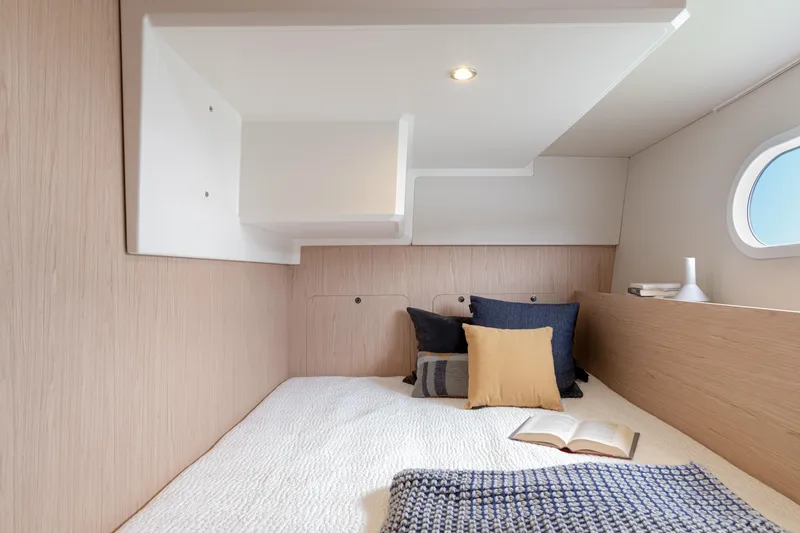 Slide: The Image of Cozy cabin interior of 2026 Beneteau Swift Trawler 41 Fly with pillows and open book. - 7