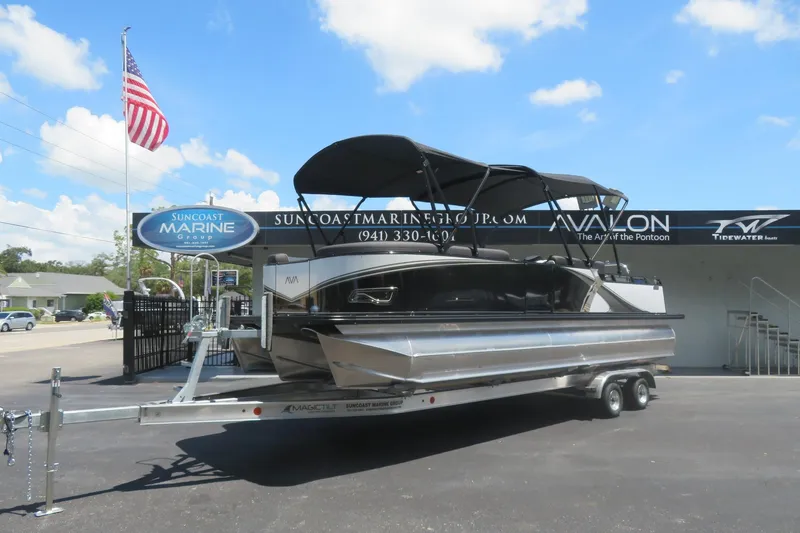 Slide: The Image of 2027 Avalon LSZ Versatile Rear Bench pontoon boat on trailer at Suncoast Marine Group. - 1