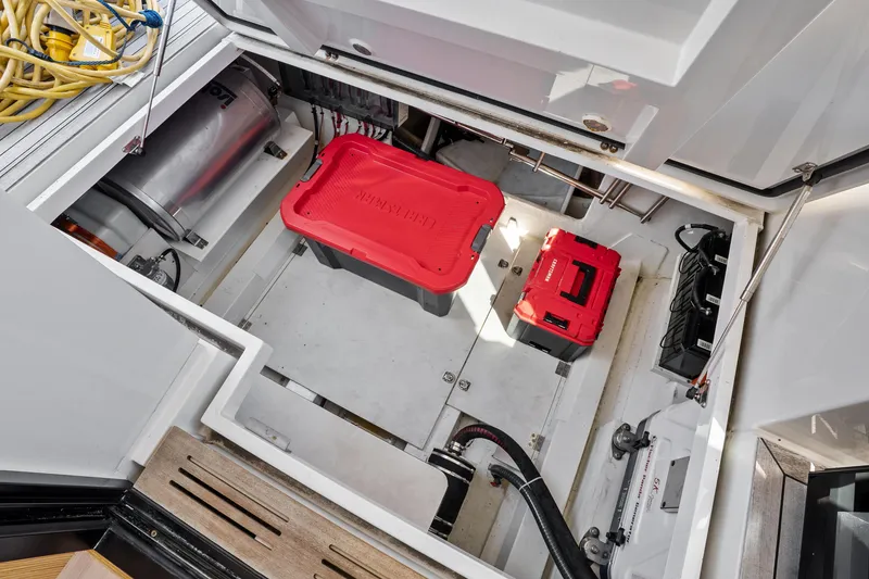 Slide: The Image of 2023 Sealine C335V yacht storage compartment with red toolboxes and equipment. - 24