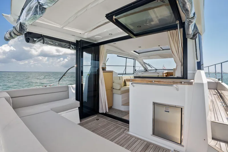 Slide: The Image of 2023 Sealine C335V yacht interior with open deck, luxurious seating, and ocean view. - 10