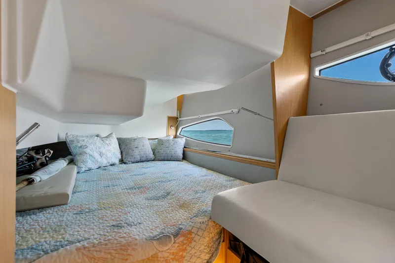 Slide: The Image of 2023 Sealine C335V cabin interior with cozy bed and ocean view window. - 23