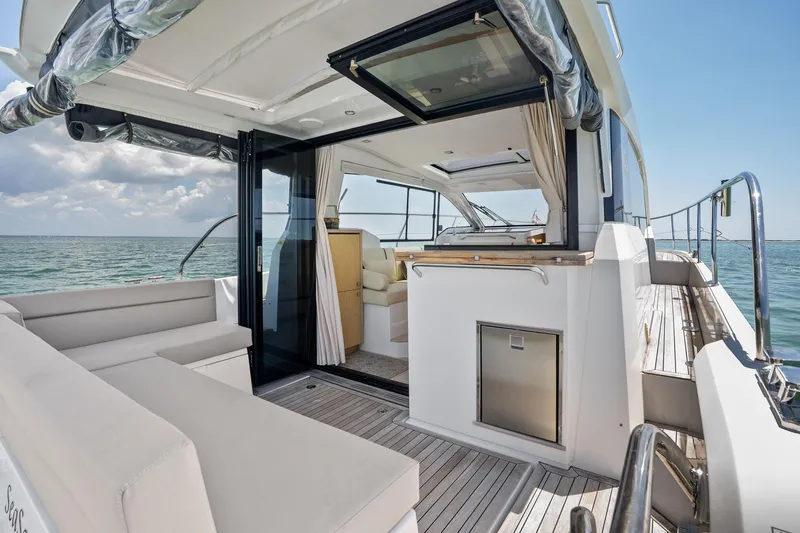 Slide: The Image of 2023 Sealine C335V yacht with open deck, luxurious seating, and ocean view. - 9
