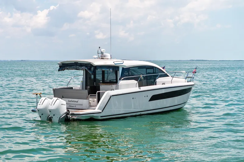 Slide: The Image of 2023 Sealine C335V yacht on calm ocean waters under a partly cloudy sky. - 2