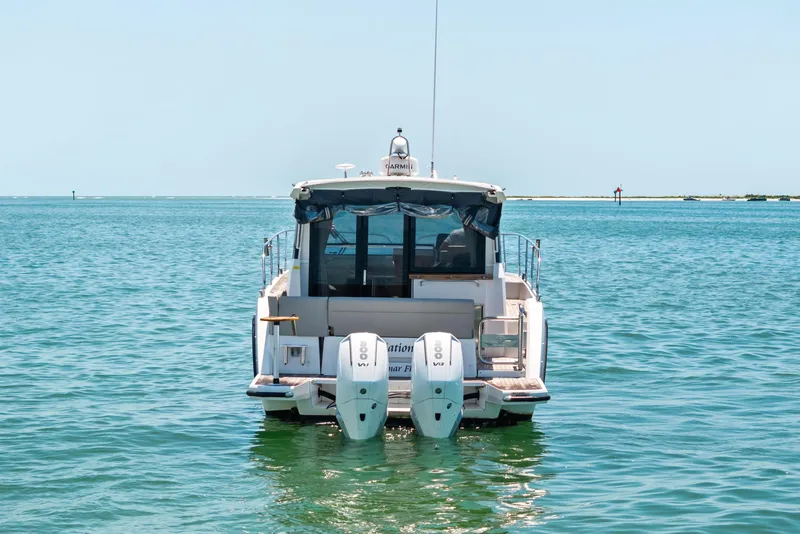 Slide: The Image of 2023 Sealine C335V boat on calm blue water, rear view with twin engines. - 3