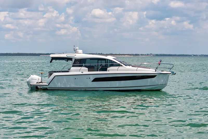 Slide: The Image of 2023 Sealine C335V yacht on calm water under a partly cloudy sky. - 1