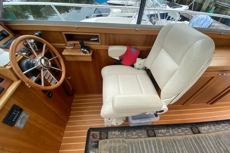Slide: The Image of Captain's chair and helm of 2014 Sabre 38 Salon Express yacht, featuring wooden accents. - 14