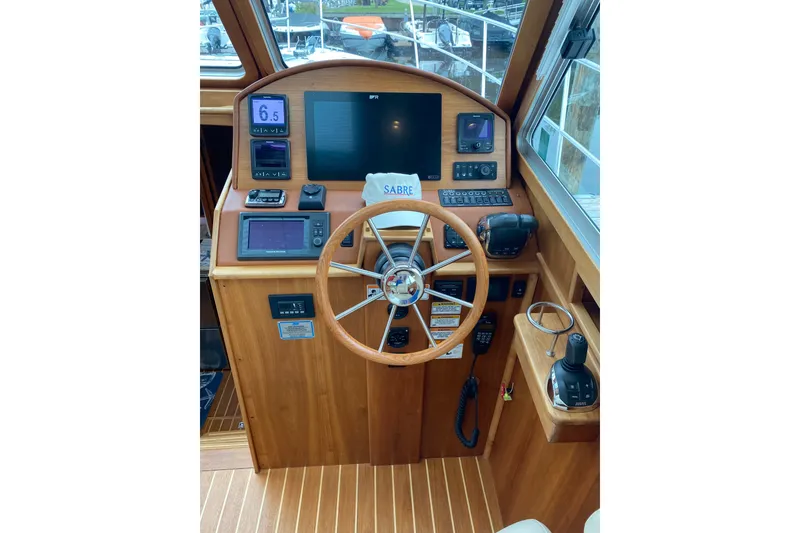 Slide: The Image of 2014 Sabre 38 Salon Express helm with wooden steering wheel and modern navigation instruments. - 15