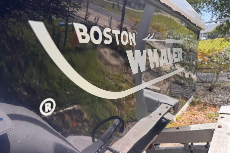 Slide: The Image of 1980 Boston Whaler 17 Montauk boat logo on hull, reflecting outdoor scenery. - 3
