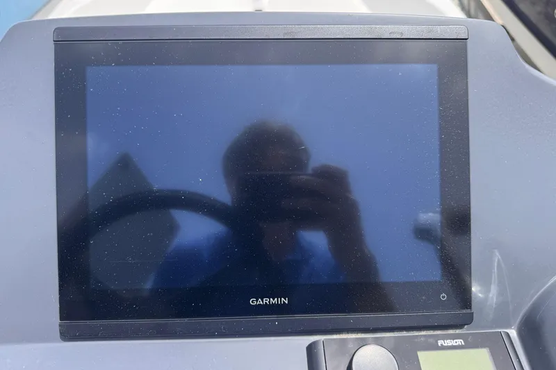 Slide: The Image of Garmin display on 1980 Boston Whaler 17 Montauk boat dashboard, reflecting a person. - 13