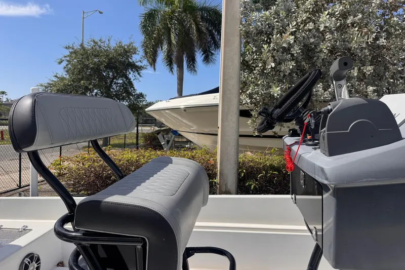 Slide: The Image of 1980 Boston Whaler 17 Montauk boat interior with steering console and seating, outdoors. - 4