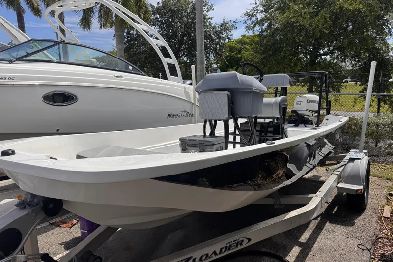 The Image of 1980 Boston Whaler 17 Montauk boat on trailer, parked beside another vessel. - 1