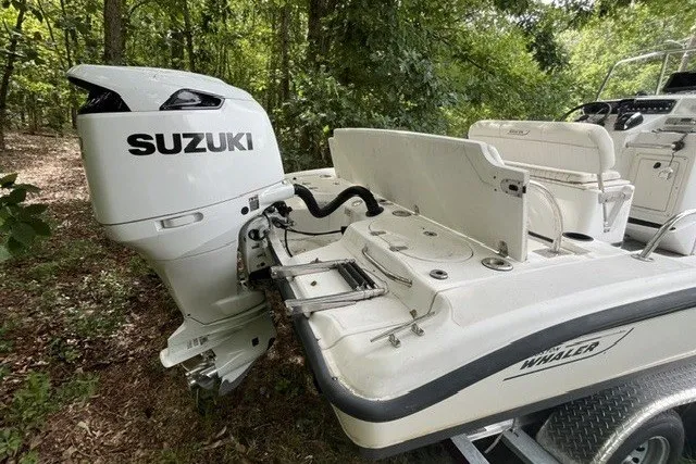 Slide: The Image of 2004 Boston Whaler 220 Dauntless boat with Suzuki outboard motor in wooded area. - 22