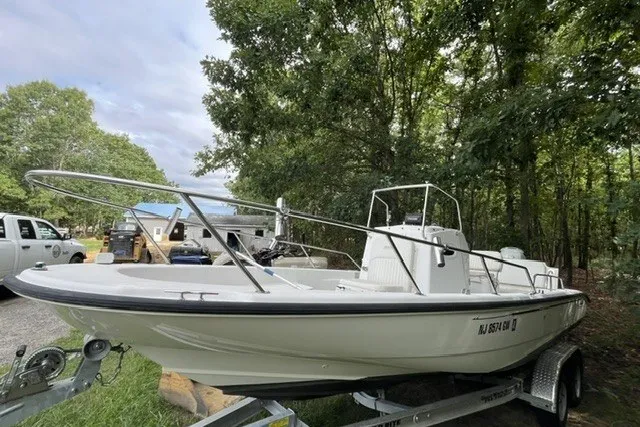 Slide: The Image of 2004 Boston Whaler 220 Dauntless boat on trailer, parked outdoors near trees. - 21