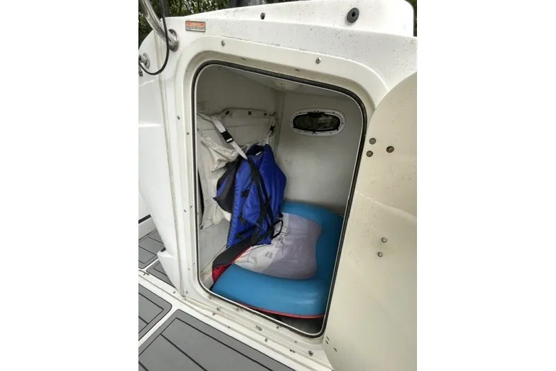 Slide: The Image of Storage compartment inside a 2004 Boston Whaler 220 Dauntless boat, featuring life jackets and gear. - 13