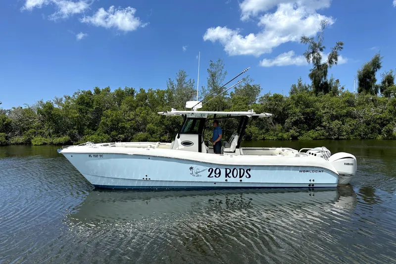 Slide: The Image of 2022 World Cat 325 CC boat on calm water, surrounded by lush greenery. - 18