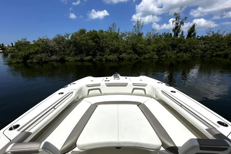 Slide: The Image of Bow view of 2022 World Cat 325 CC boat on calm water, surrounded by lush greenery. - 10