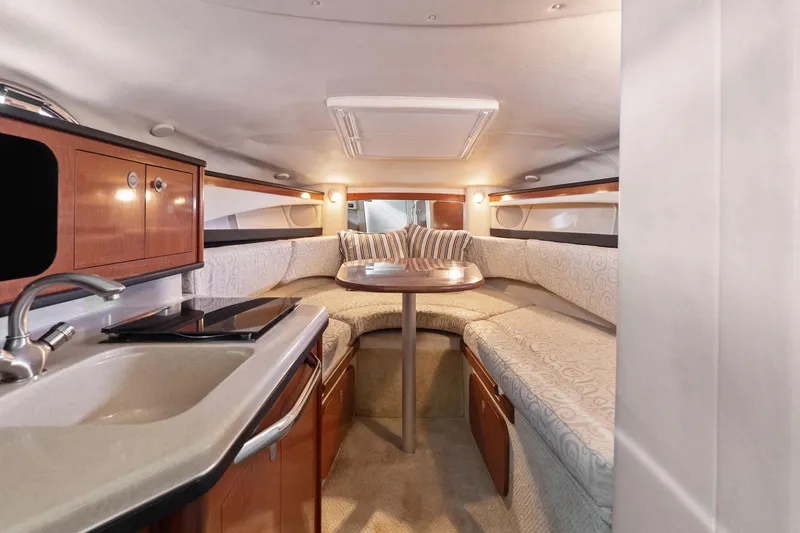 Slide: The Image of Interior of 2005 Sea Ray 270 Amberjack boat with cozy seating and kitchenette. - 19