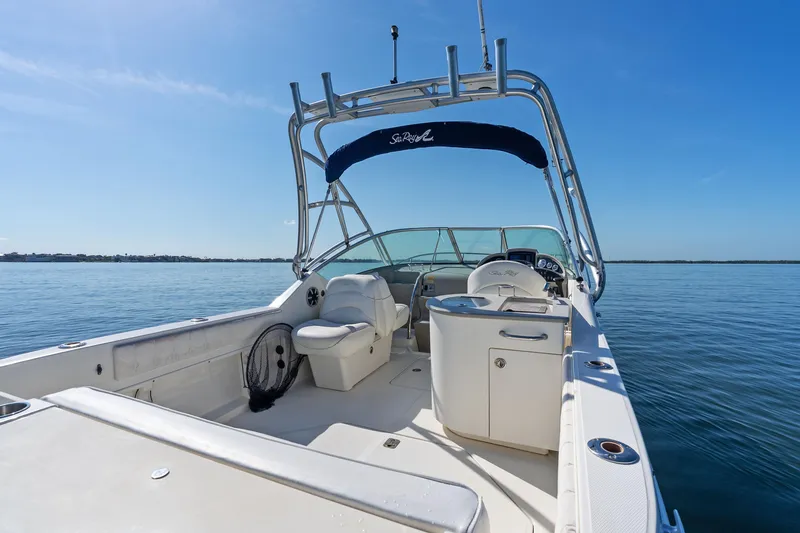 Slide: The Image of 2005 Sea Ray 270 Amberjack boat interior with seating and helm, on calm water. - 9