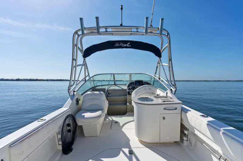 Slide: The Image of 2005 Sea Ray 270 Amberjack boat interior with helm and seating on calm water. - 11